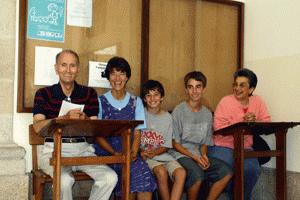 Amadeu, Therese, Paul, Peter and Helen sit in the hallway of Amadeu's high school 65 years later.